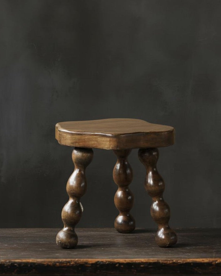 oak vintage Wooden footstool stool with turned legs on a dark background