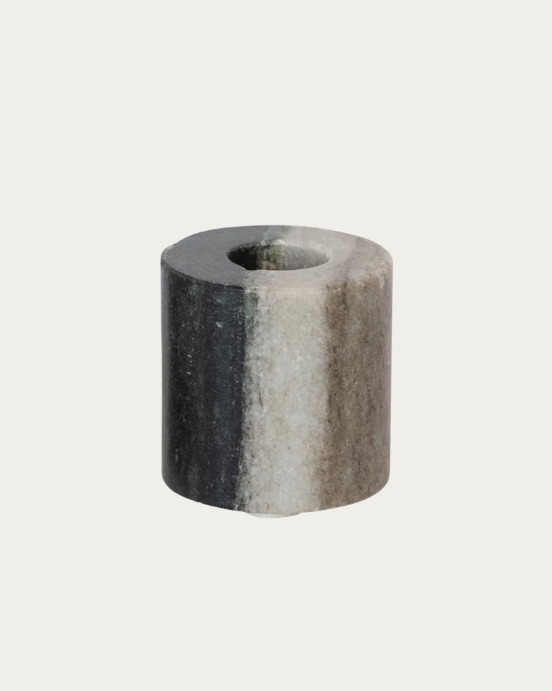 Gray cylindrical stone object on a light gray background