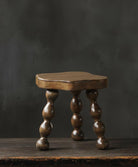 oak vintage Wooden footstool stool with turned legs on a dark background