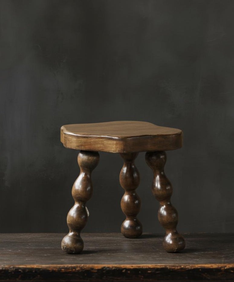 oak vintage Wooden footstool stool with turned legs on a dark background
